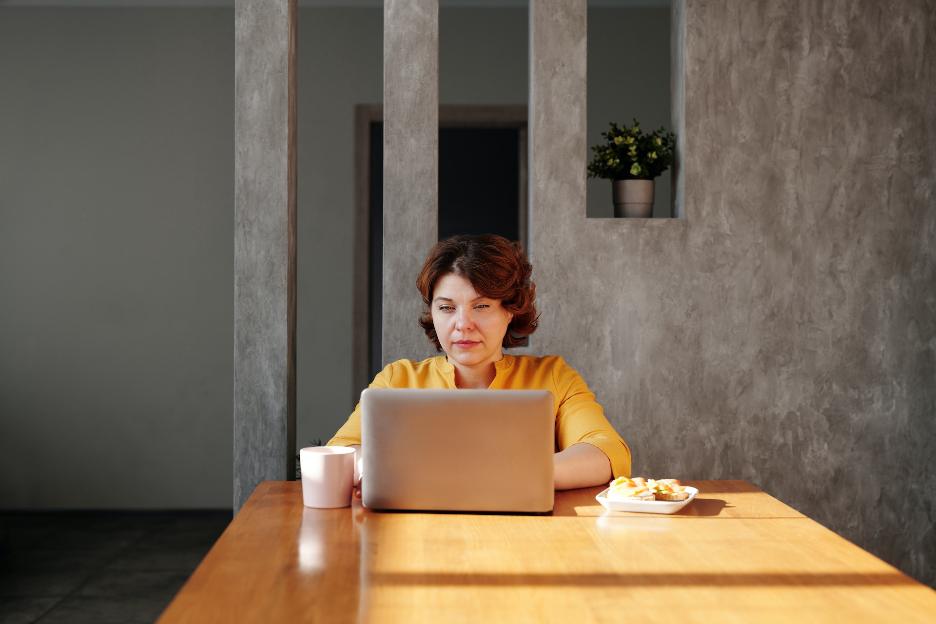 Kobieta siedząca przy biurku patrząca w ekran laptopa nawiązując kontakt na LinkedIn